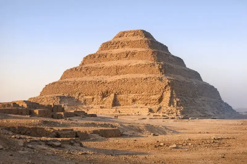 Step Pyramid of Djoser at Saqqara, Egypt, rising above desert with surrounding mastaba tombs